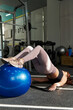 young Caucasian woman using swiss ball workout to strengthen the buttocks, vertical orientation