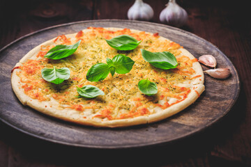 Wall Mural - Pizza bread with garlic, cheese and basil on wooden background