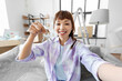 © Syda Productions - moving, people and real estate concept - happy smiling asian woman with house keys taking selfie or having video call at new home