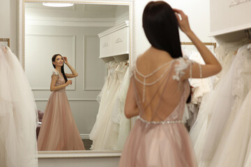 Wall Mural - Woman trying on beautiful wedding dress in boutique