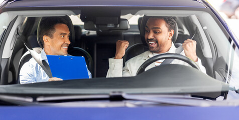 Wall Mural - driver courses, exam and people concept - happy smiling indian man and driving school instructor with clipboard in car