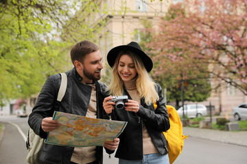 Poster - Couple of tourists with map and camera on city street