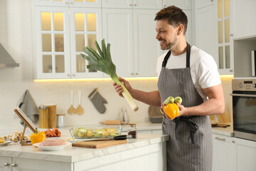 Poster - Man making dinner while watching online cooking course via tablet in kitchen