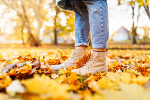 Legs Of Woman Wearing Brown Leather Shoes In Autumn Yellow Foliage Walking In Park Or Forest