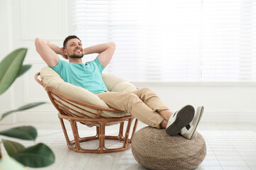 Poster - Handsome man relaxing in papasan chair at home, space for text