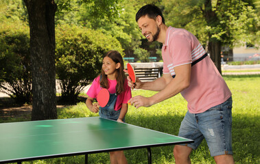 Sticker - Happy man with his daughter playing ping pong in park