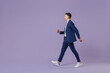 © ViDi Studio - Full size body length side view young successful employee business man lawyer 20s wears formal blue suit white t-shirt work in office move stroll isolated on pastel purple background studio portrait.
