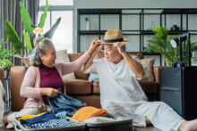 Old Asian Senior Couple Packing Cloth And Stuff For A Trip Together,happiness Asian Old Age Retired Mature Adult Enjoy Arrange Cloth Together On Floor At Living Room At Home Interior Background