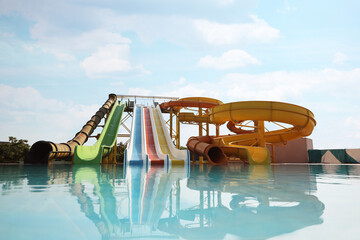 Wall Mural - Beautiful view of water park with colorful slides and swimming pool on sunny day