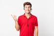 young handsome man feeling happy, surprised realizing a solution or idea. telemarketer concept