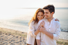 Smiling Young Couple Two Friends Family Man Woman 20s In Casual Clothes Hug Girlfriend Put Head On Boyfriend Shoulder At Sunrise Over Sea Sand Beach Ocean Outdoor Seaside In Summer Day Sunset Evening.