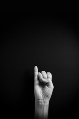 B&W image of hand demonstrating ASL sign language letter I with empty copy space