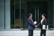 © DragonImages - Positive experienced business people shaking hands after meeting outdoors to discussing collaboration details