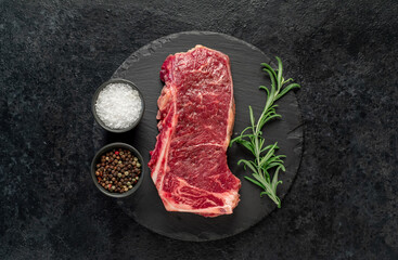 Wall Mural - Raw marbled beef New York steak with spices on a stone background