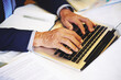 © DragonImages - Hands of senior businessman working on laptop, answering e-mails and correcting contract details