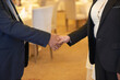 © DragonImages - Close-up image of senior business partners shaking hands before having meeting in restaurant