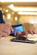 © DragonImages - Hands of senior businessman using credit card to pay for purchases he makes online via application on tablet computer