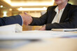 © DragonImages - Hands of senior business partners shaking hands over restaurant table after successful meeting