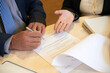 Close-up image of business partners signing contract after successful meeting