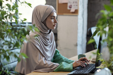 Aufkleber - Serious Muslim female in hijab looking at computer screen while networking