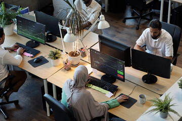 Wall Mural - Several co-workers looking at information on computer screens in office