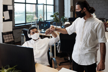 Aufkleber - Young successful businessmen with protective masks bumping elbows instead of handshake