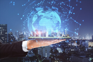 Poster - Close up of businessman hands holding tablet with abstract glowing connections globe on night city background.