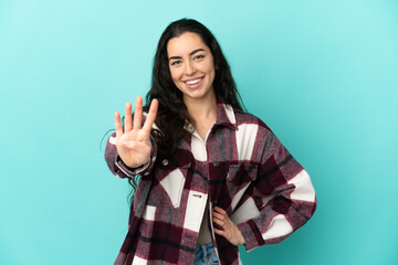 Young caucasian woman isolated on blue background happy and counting four with fingers