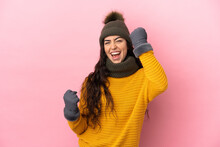 Young Caucasian Girl With Winter Hat Isolated On Purple Background Celebrating A Victory