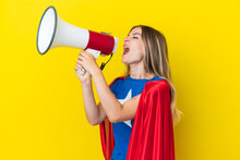 Super Hero Romanian Woman Isolated On Yellow Background Shouting Through A Megaphone