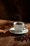 Fototapeta  -  Xícara de café isolado em fundo de madeira rústica, na vertical, com grupos de grãos de café selecionados en torno.