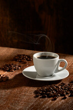  Xícara de café isolado em fundo de madeira rústica, na vertical, com grupos de grãos de café selecionados en torno.