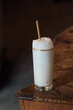 Ramos gin fizz milkshake white foam in gold-rimmed tall glass with gold drinking straw