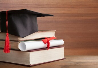 Canvas Print - Graduation hat on a stack of books and diploma