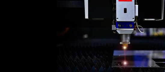 Wall Mural - industrial laser cut machine while cutting the sheet metal with the sparking light. free space on le