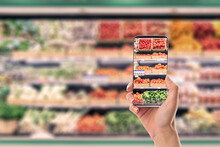 Mobile phone in hand with a picture of groceries in it.