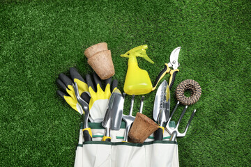 Poster - Flat lay composition with gardening tools on green grass