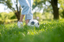Feet Of Junior Child With Soccer Ball On Grass