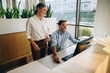 © Jacob Lund - Manager standing by employee working in office