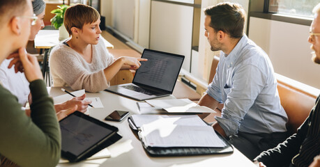 Female executive showing data to team in meeting