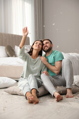 Poster - Happy young couple resting after fun pillow fight in bedroom