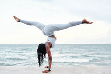 Strong Fit Young Woman Doing Handstand Splits On Sandy Beach