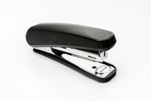 Black Stapler Used To Bind Paper. A Common Stationary In Office Isolated On White Background.