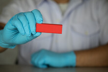 A Doctor Or Scientist Medical Wearing Blue Gloves Holds A Wooden Red Stick