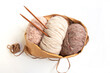 Skeins of yarn in nude colors in a craft bag and knitting needles on a bright background