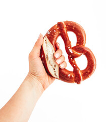 Wall Mural - Female hand holding traditional Bavarian pastry Bretzel. German salty bakery pretzel, beer snack, isolated on white background.