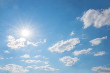 Wall Mural - cloudscape with bright sun, fluffy cumulus clouds and copy space