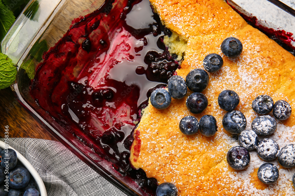 Baking dish with blueberry cobbler on table, closeup