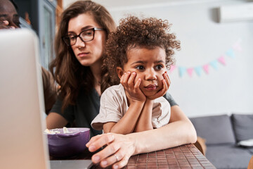 Wall Mural - Girl looking with bored emotions while showing to parents that she does not want to eat