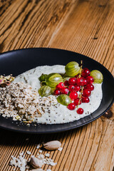 Wall Mural - Breakfast smoothie bowl with gooseberries, red currants, rolled oats, pistachios